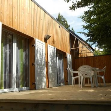 Cottage en bois avec terrasse privée donnant sur la pelouse du camping