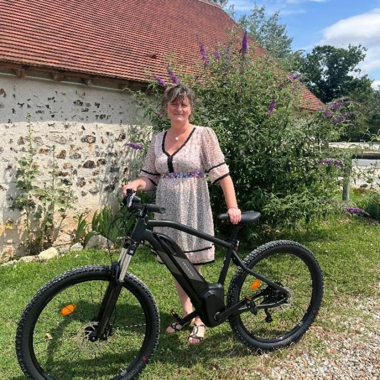 Vélo à assistance électrique de location devant un bâtiment en pierre