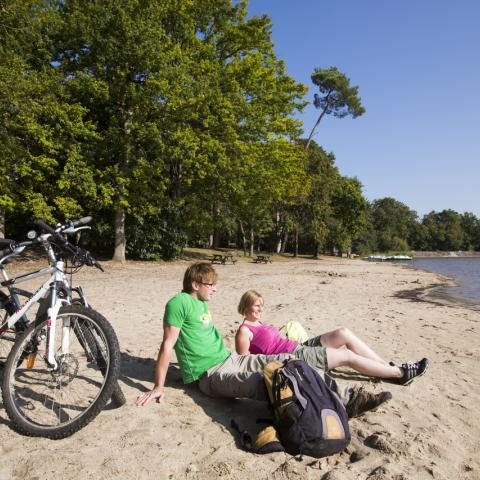 Plage de sable de Bellebouche avec des vélos posés et des baigneurs